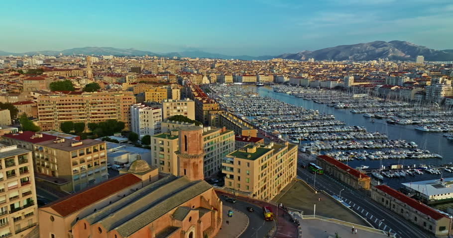 Many boats and yachts are parked in the city marina. Aerial view of the port of Marseille in the morning sun. Drone view of Marseille in the south of France