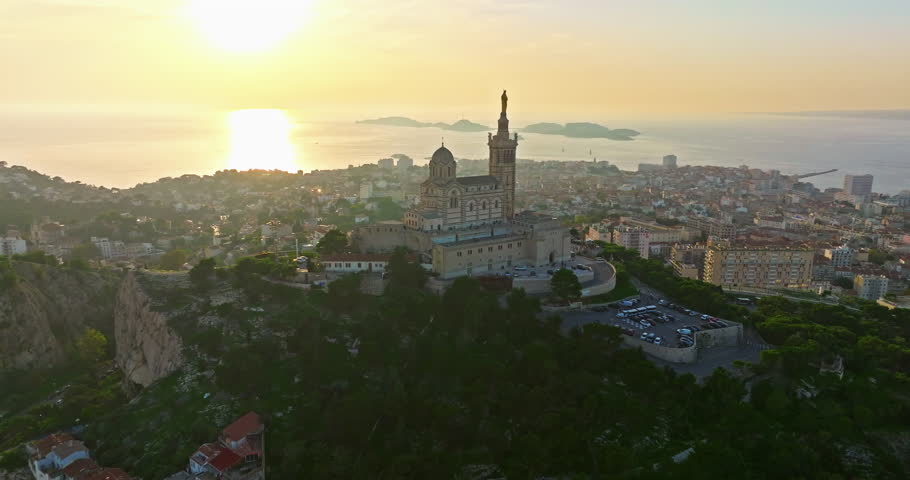 Aerial view of the Notre Dame de la Garde or Our Lady of the Guard church at sunset, southern France. The warm summer evening light illuminates the Marseille cityscape