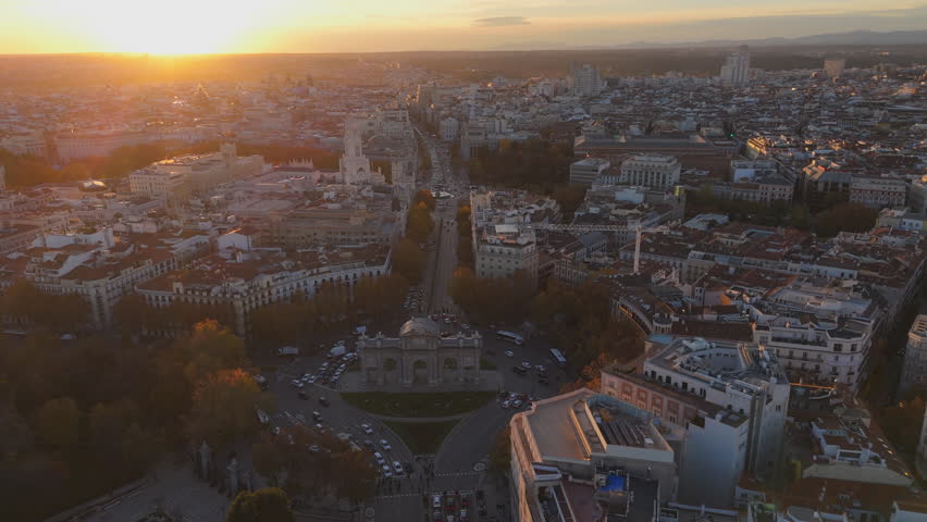 Experience breathtaking aerial drone shots over Madrid, highlighting the iconic Puerta de Alcal during a picturesque sunset