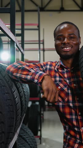 African American man carrying a tire in an auto parts store