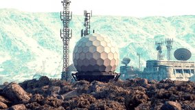 A military base in a mountainous region is visible, showcasing large communication domes and various antenna towers nestled among rocky terrain. The landscape is rugged and expansive. - Powered by Shutterstock - Get 15% off with code: PIKWIZARD15