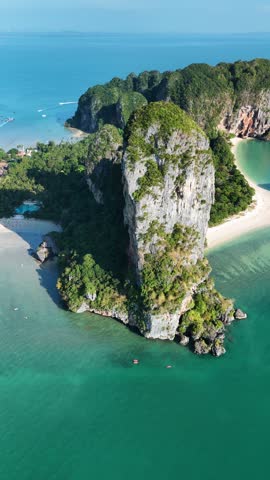 Explore stunning limestone formations rising dramatically from the turquoise waters in Thailand. This serene coastal landscape highlights the natural beauty and vibrant colors of Railay beach Krabi