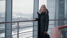 Woman in black jacket standing close to glass window, gazing out while observing passing cars, with urban setting visible in background - Powered by Shutterstock - Get 15% off with code: PIKWIZARD15