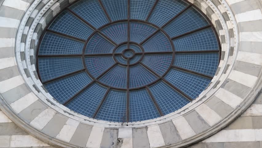 Detailed circular stained glass window with geometric pattern on San Lorenzo Cathedral in Genoa, Italy, showcasing Romanesque-Gothic architecture in daylight - Powered by Shutterstock - Get 15% off with code: PIKWIZARD15