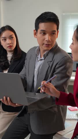 Business team collaborating, analyzing financial data on laptop, developing growth strategies, and fostering teamwork in modern office environment