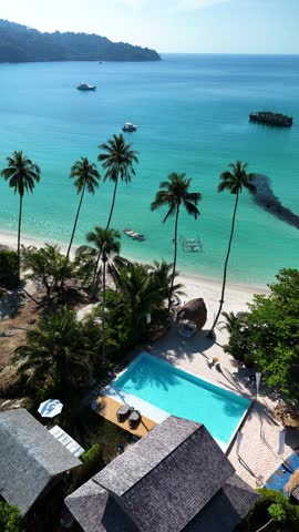 Discover a stunning tropical paradise in Thailand where pristine turquoise waters meet sandy beaches. The inviting pool and swaying palm trees create a relaxing escape.
