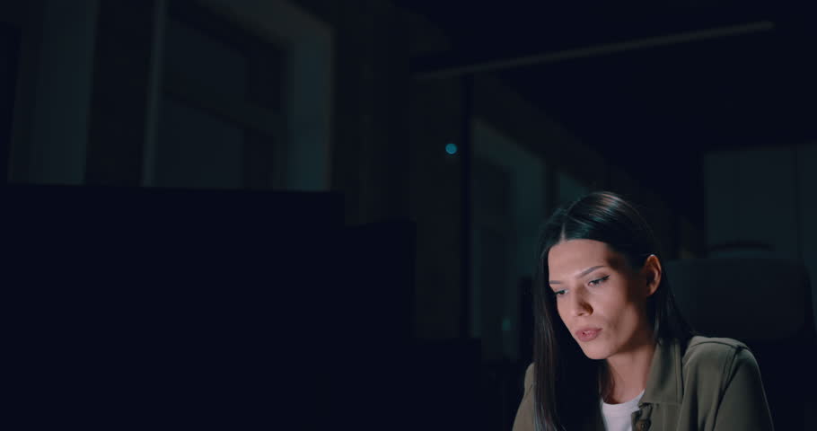 Female businesswoman employee working late in the office, using a laptop while feeling tired and burnt out. Reading, copywriting, editing, and struggling with fatigue and brain fog on a tight deadline