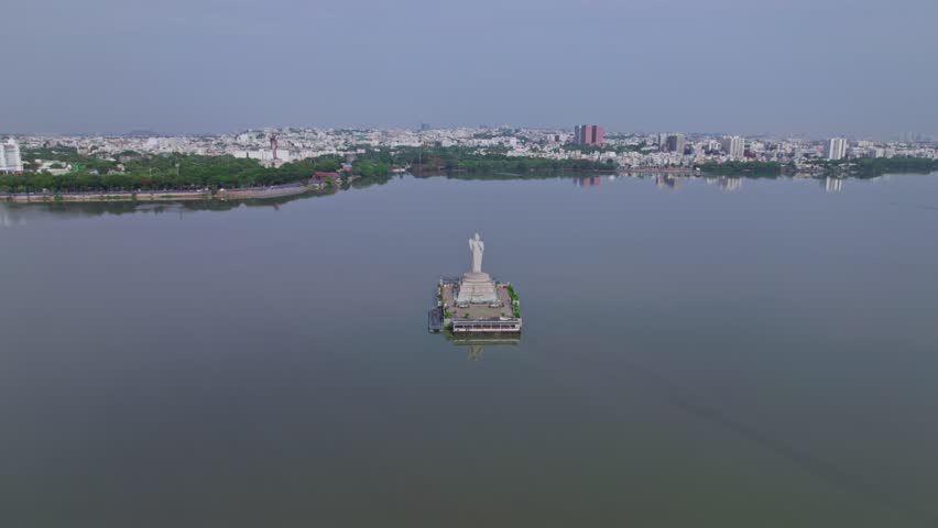 Hussain Sagar Lake with buddha statue in background crowded building at tank bund, Khairtabad, Hyderabad, Telangana, india. day time, push in, drone shot, 4k.