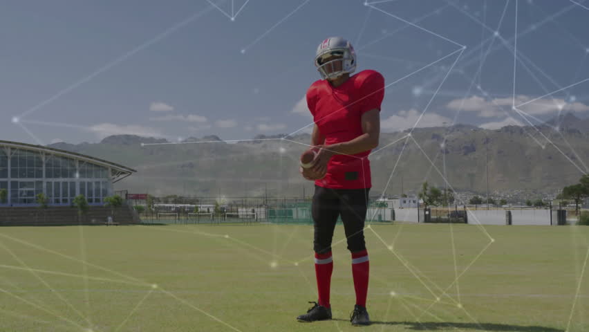 Holding football, player in red uniform with animation of network connections. Soccer, technology, digital, connectivity, athlete, teamwork - Powered by Shutterstock - Get 15% off with code: PIKWIZARD15