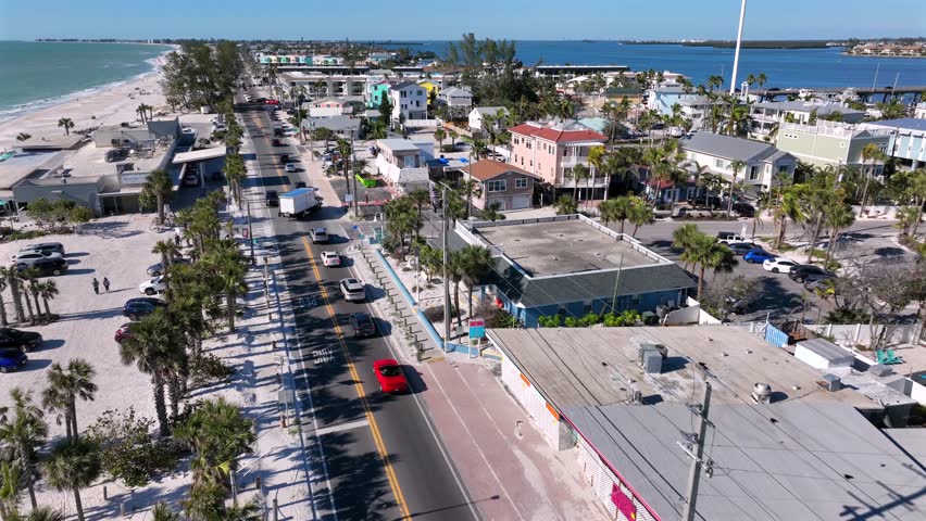 Palm tree lined Avenue along main street with traffic jam in Bradenton, Florida. Colored facade of houses and buildings in tropical city, America. Aerial birds eye wide shot.