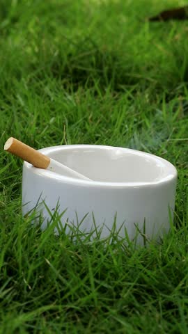 close up shot of a lit cigarette in an ashtray