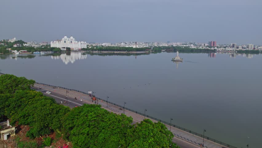 aerial view of tank bund with status, buildings and Telangana Secretariat reflections on water at hussain sagar lake, khairtabad, hyderabad, india. day time, static shot, drone shot, 4k.