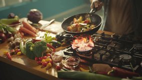 Dynamic shot of an unrecognizable chef is tossing vegetables on frying pan at professional kitchen. High quality 4k footage - Powered by Shutterstock - Get 15% off with code: PIKWIZARD15