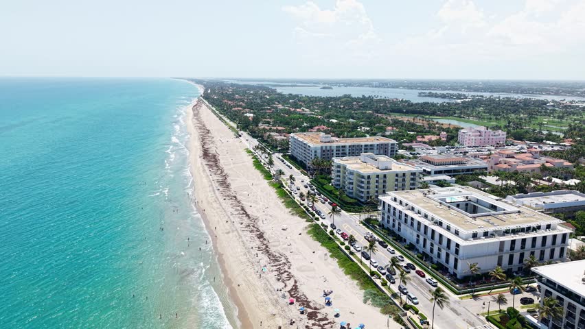 Aerial: Municipal Beach next to Atlantic Ocean with hotels during the day in West Palm Beach, Florida, USA, orbit drone shot