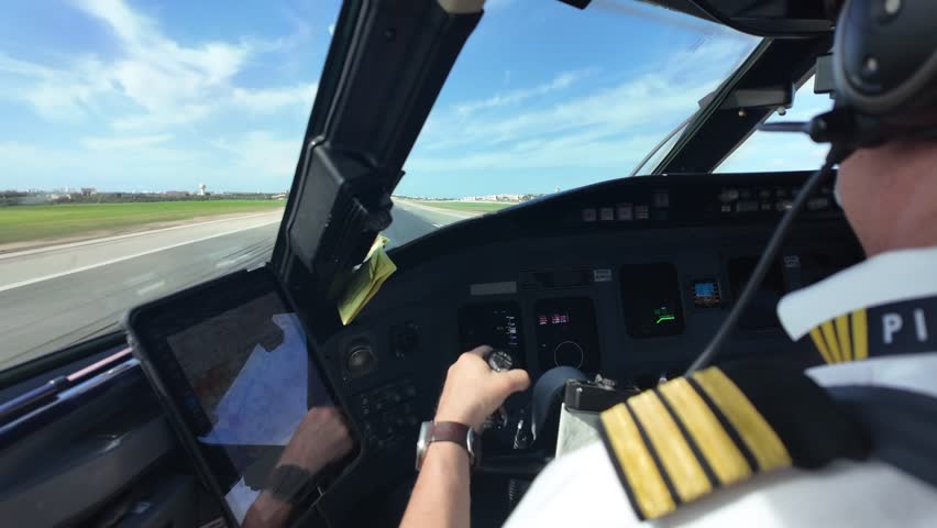 An immersive cockpit view, through the pilot’s eyes from a jet cockpit, in a real time landing, with the runway ahead, under a sunny and blue sky with few clouds. 4K