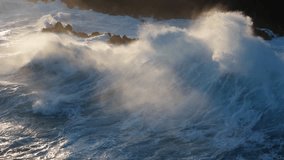Huge power ocean wave crashing over sunset sky background. Slow motion of stormy ocean surf splashing on the coast of Madeira, Porto Moniz - Powered by Shutterstock - Get 15% off with code: PIKWIZARD15