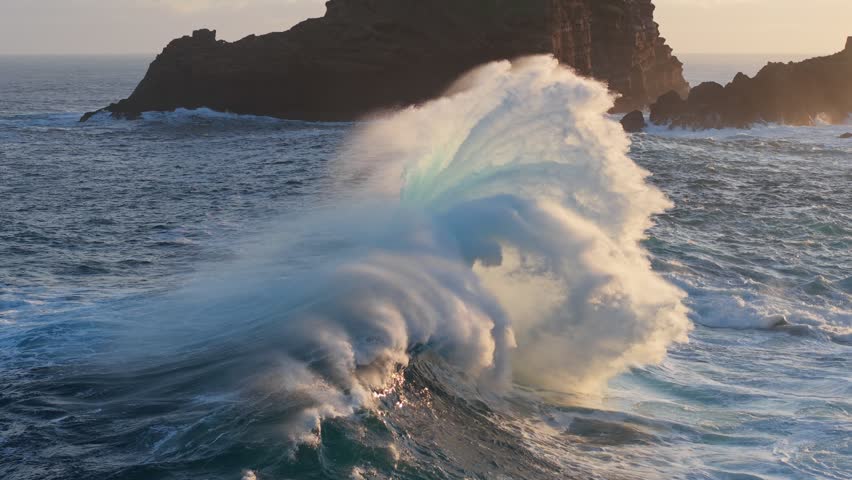 Slow motion epic shot of ocean wave splashing. Huge wave with turquoise water off the coast of the Atlantic Ocean. Big surf crash