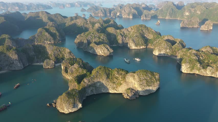 Top view of green vegetated karst islands and several boats sailing in Lan Ha Bay, near Cat Ba island, Vietnam