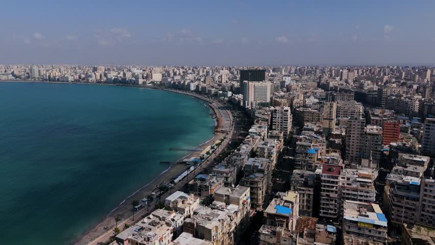 Cars Driving In The Road Along The Waterfront Buildings In Alexandria City In Egypt - aerial shot