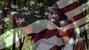 In forest, couple exploring with American flag animation overlay in foreground. Adventure, exploration, nature, patriotism, travel, hiking - Powered by Shutterstock - Get 15% off with code: PIKWIZARD15