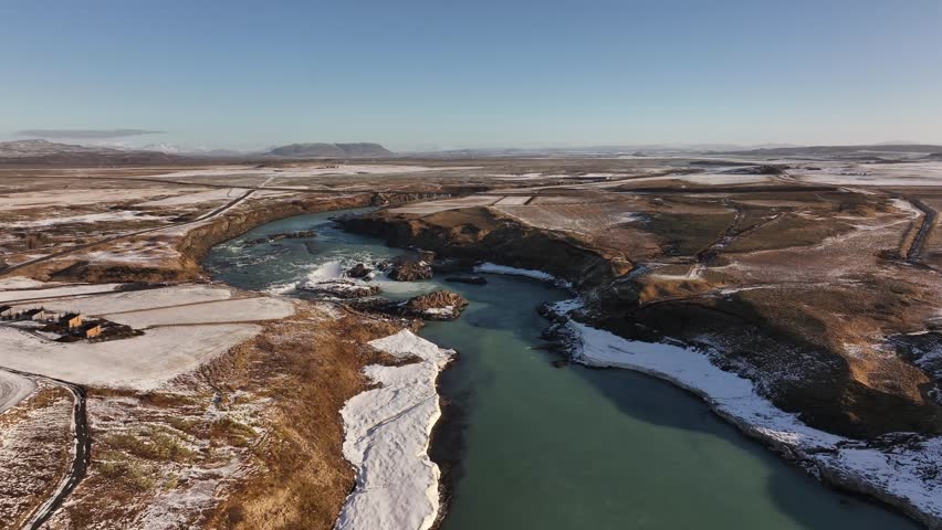 Majestic aerial view of Urriðafoss waterfall in Iceland, showcasing rugged landscapes and icy terrain
