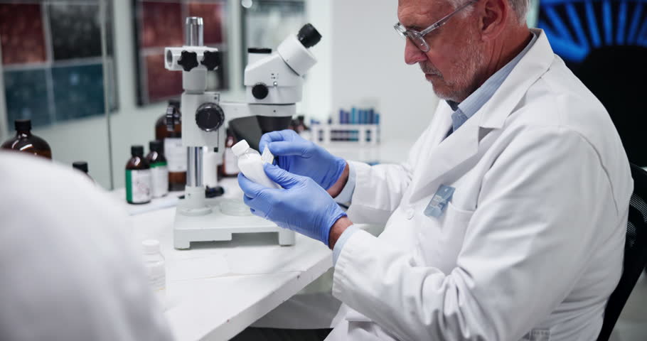 Label, pharmacist and man with medicine, lab and info for treatment of disease, healthcare and science. Pharmaceutical, medical professional and mature person with container, serious and antibiotics