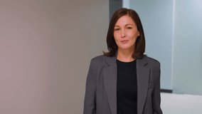 Professional woman in business attire standing confidently with arms crossed in modern office hallway. Serious expression with neutral background suggesting leadership, business - Powered by Shutterstock - Get 15% off with code: PIKWIZARD15