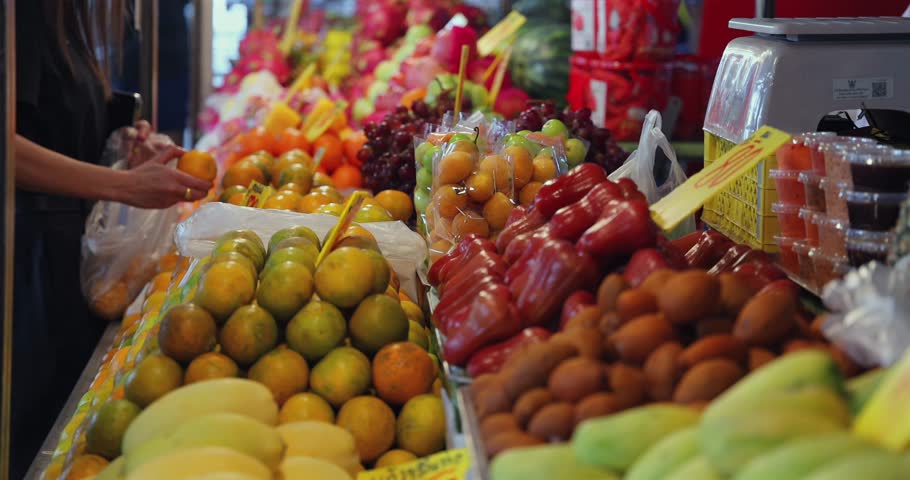 Vibrant fruit market fresh produce display, Thailand night market customers shopping, local food street market authentic experience tourism.