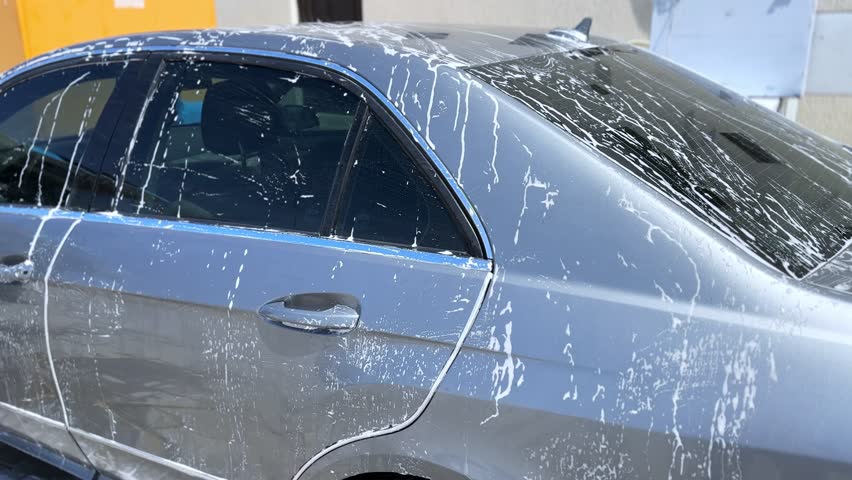 Experience the art of auto care with this stunning 4K footage capturing suds cascading over a sleek luxury car. Ideal for car care, commercials, or automotive design visuals.