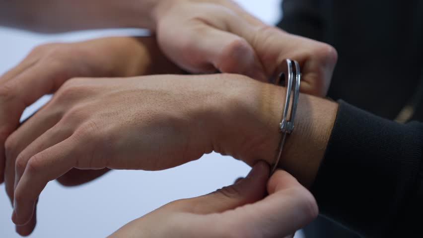 Policeman Handcuffs Suspect During Arrest Procedure