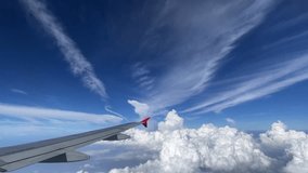 A breathtaking aerial view beautifully displaying an airplane wing gliding above fluffy clouds and vivid blue skies. Stunning Aerial View of Fluffy Clouds and an Airplane Wing Captured During Flight - Powered by Shutterstock - Get 15% off with code: PIKWIZARD15