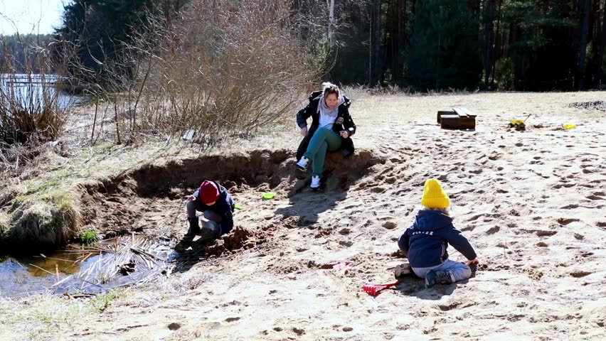 Kids enjoy playful moments at the lakeside beach on a sunny spring day with family bonding activities