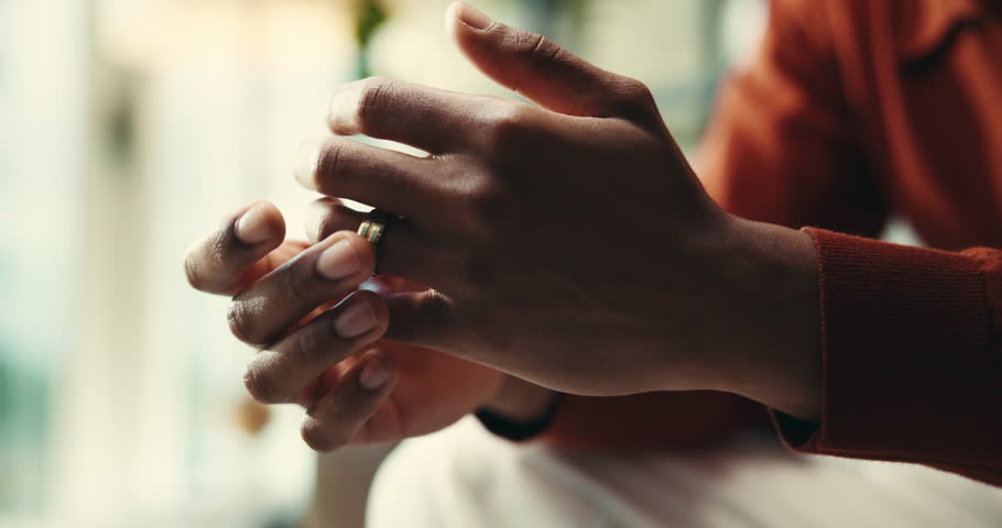 Divorce, wedding ring and decision with hands of person for thinking, separation and stress. Jewelry, frustrated and reflection with closeup at home for relationship mistake, cheating and memory