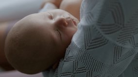Close-up, mother lulls her newborn baby to sleep by rocking him in her arms. Healthy sleep. Motherhood. Mother's Day. Family. Childbirth. Slow motion video 4K - Powered by Shutterstock - Get 15% off with code: PIKWIZARD15