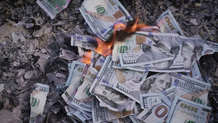 Burning US Dollar Bills on Ashes Representing Financial Loss and Waste