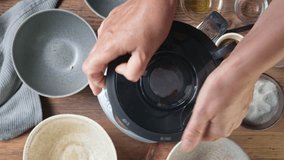 The cook puts ice cubes into the blender container with the gazpacho soup ingredients and closes the lid, top view - Powered by Shutterstock - Get 15% off with code: PIKWIZARD15