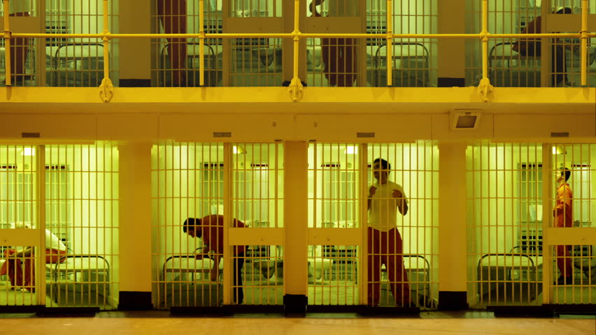 Prisoners serving time in a large cell block. Composite clip created by putting