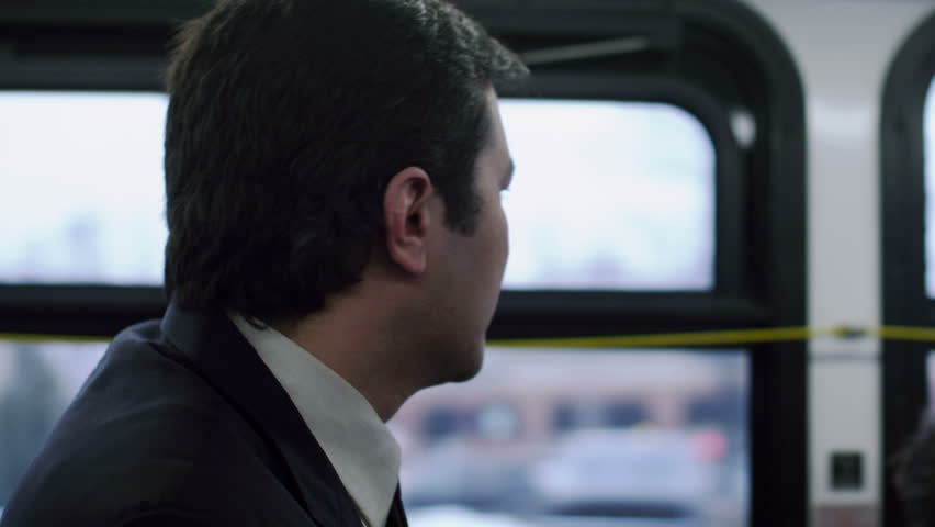 Man in a suit, riding the bus. Close up.