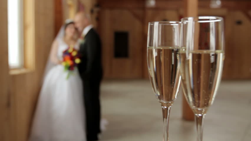 Rack focus from Champagne flutes to bride and groom.