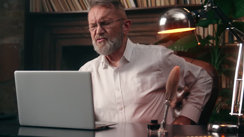 Old Caucasian man work laptop computer back pain health medicine suffer male pensioner elderly businessman office feel ache backache disease arthritis overwork spine osteoporosis business home problem