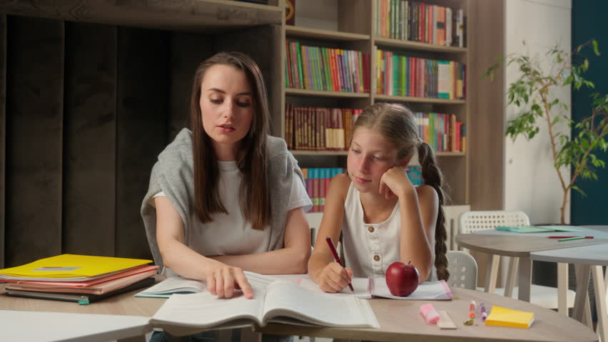 Caucasian woman teacher tutor child little girl team school learning studying schoolgirl classroom showing thumbs up like approval recommend gesture education good lesson together pupil kid student