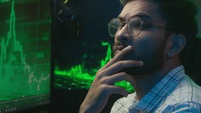 Thoughtful Arabian Indian man pondering thinking analyzing chart male guy looking at camera smiling nodding portrait confident trader businessman business analyst programmer neon office night trading - Powered by Shutterstock - Get 15% off with code: PIKWIZARD15