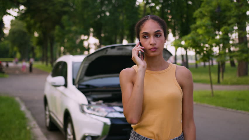 Sad worried African American woman talking mobile phone broken accident car auto female girl stressed driver insurance vehicle service repair city outdoor businesswoman calling smartphone automobile