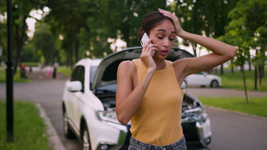 Sad worried African American woman talking mobile phone broken accident car auto female girl stressed driver insurance vehicle service repair city outdoor businesswoman calling smartphone automobile