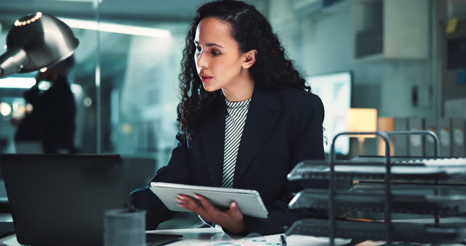 Laptop, business woman and tablet at desk for investment deal, commercial broker and checking report at night. Account agent, professional and digital app for portfolio review and project negotiation