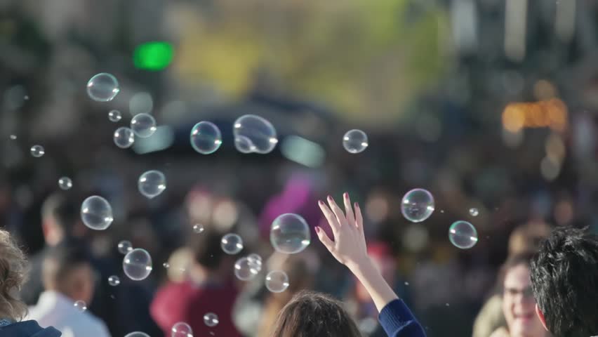 Soap bubbles floating over a blurred crowd