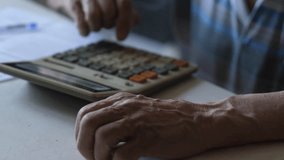 Retiree calculating expenses and income on calculator, hands of elderly man pressing calculator buttons and writing payment documents, senior family budget - Powered by Shutterstock - Get 15% off with code: PIKWIZARD15