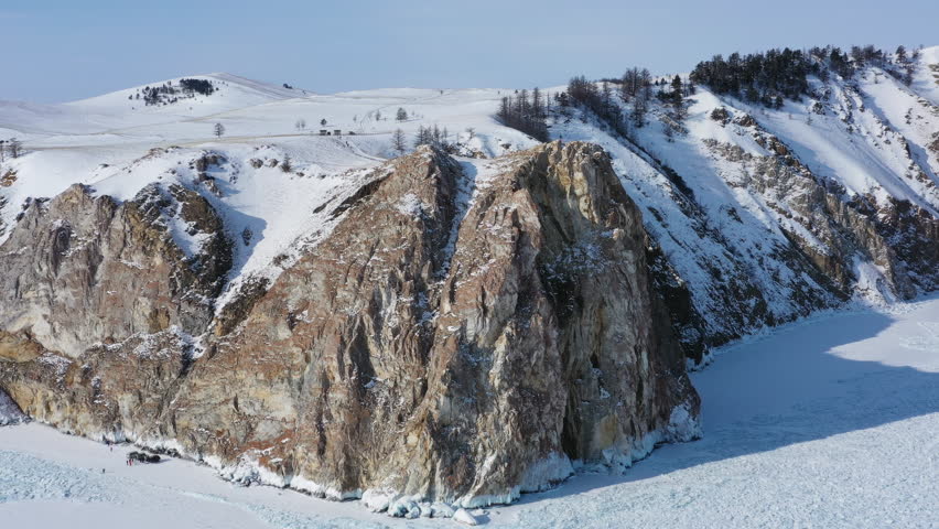 Aerial around view of frozen Lake Baikal, Olkhon Island, Rock cape. Siberia, Russia, 4k