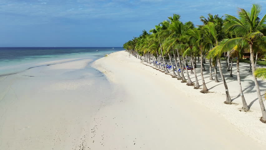 Aerial view of beautiful tropical beach with white sand and palm trees under blue sky, Philippines, 4k