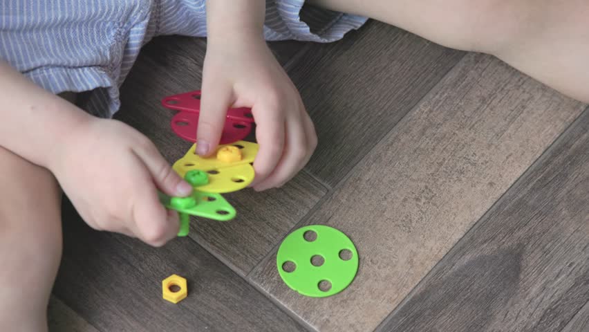 A child engages with colorful building toys that enhance fine motor skills and creativity through play